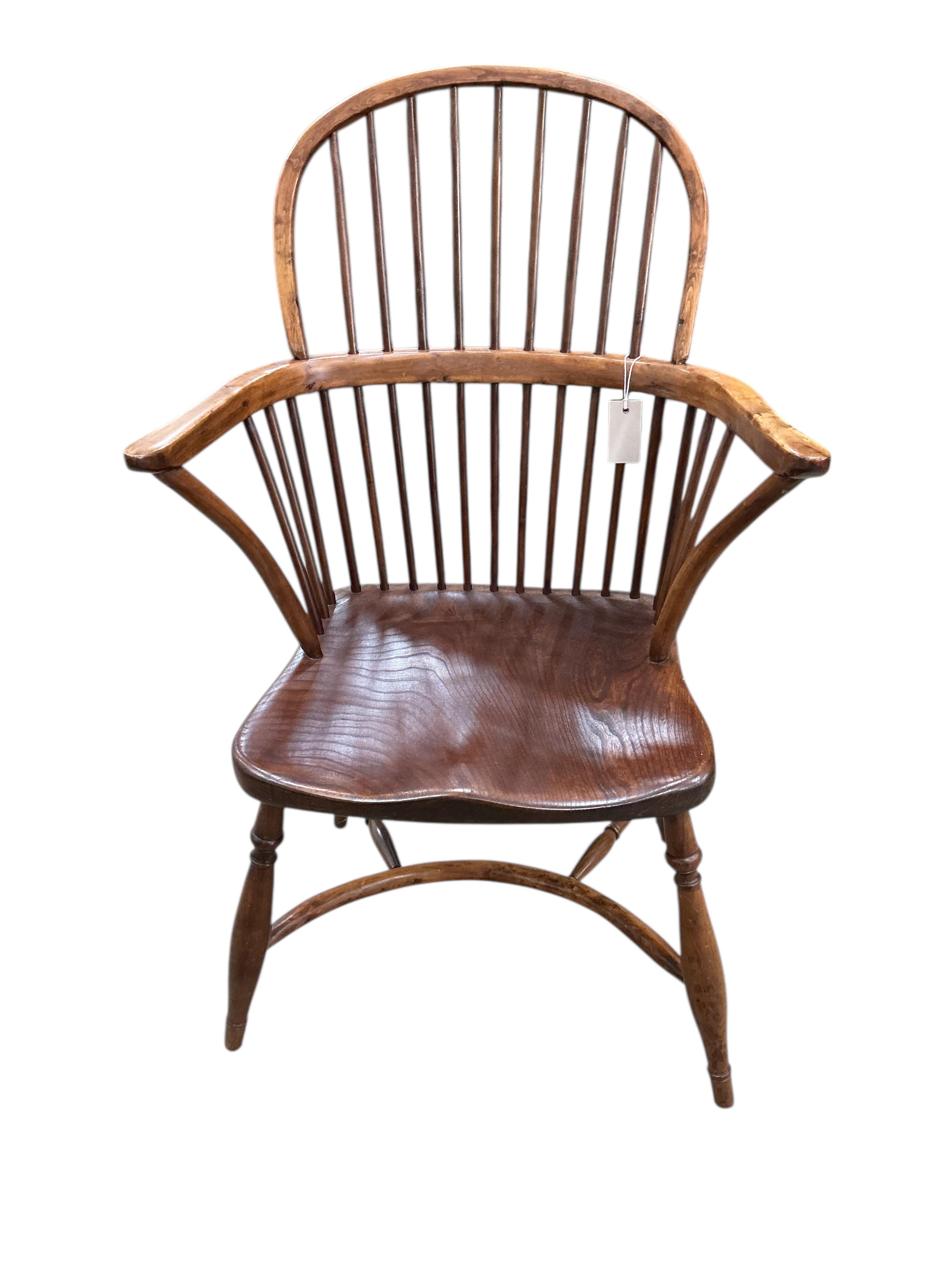 A yew and elm Windsor comb back elbow chair with crinoline stretcher, width 59cm, depth 42cm, height 96cm